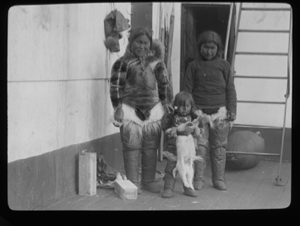 Image of Two Inuit women, girl with pup, aboard